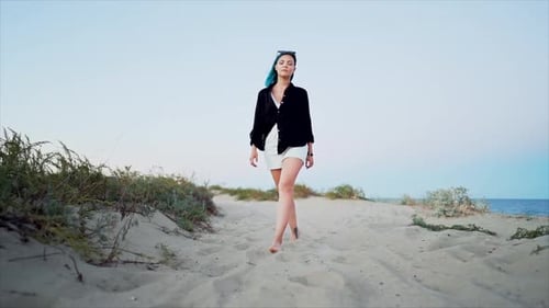 Woman with Unusual Blue Dyed Hair Walking Barefoot on Sandy Beach Alone. Slow Motion. Girl Walks To