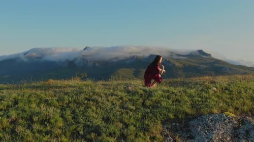 Woman Dances on Grassy Mountain Top