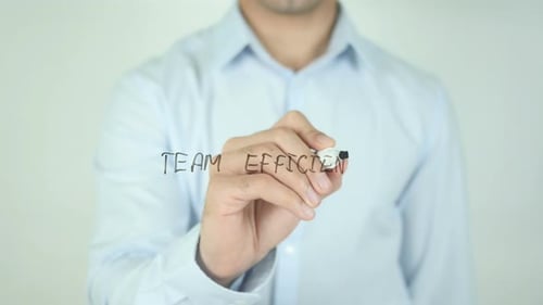 Man Writes Team Efficiency on Glass Surface