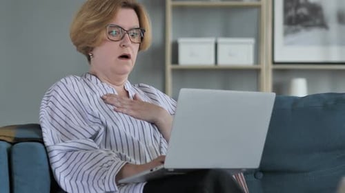 Woman Shocked While Using Laptop on Couch