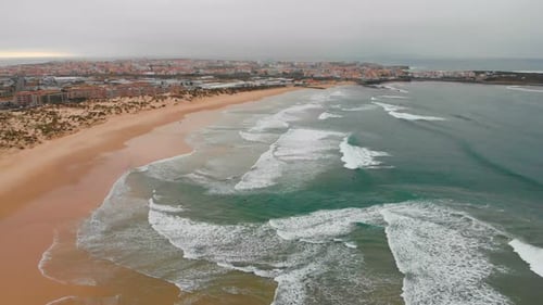 Aerial View of Sea Waves Break on Yellow Sand Beach Peniche Portugal
