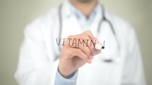 Doctor Writes the Words Vitamin D on Glass