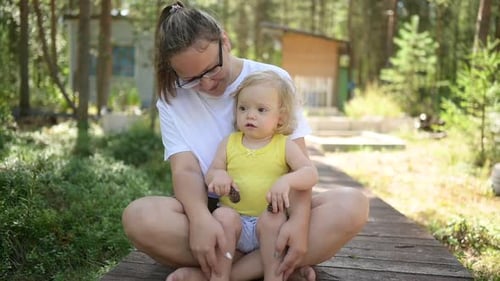 Woman and Child Sitting Together Outdoors in Nature
