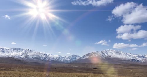 Timelapse of Sun Movement on Crystal Clear Sky with Clouds Over Snow Mountain Top