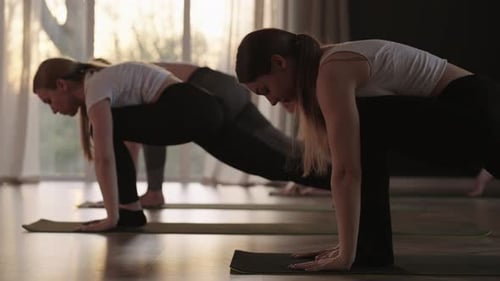 Women Practicing Yoga in a Studio at Sunrise