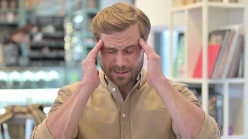 Man Massaging Temples While Experiencing Headache