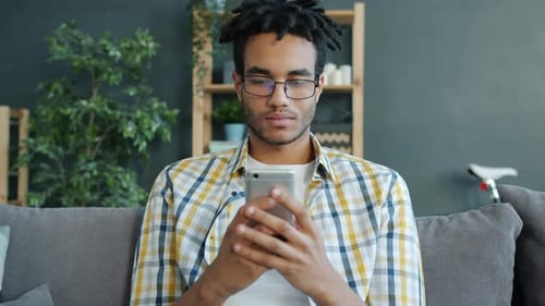 Young Adult Using a Smartphone While Relaxing Indoors