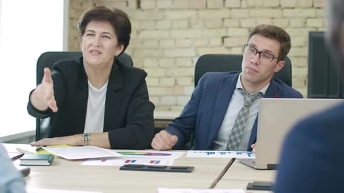 Confident Multiethnic Business Partners Talking and Shaking Hands in Office. Caucasian and African