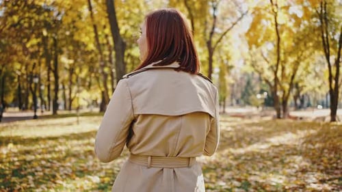 Young Woman Looking Around Walking By Autumn City Park