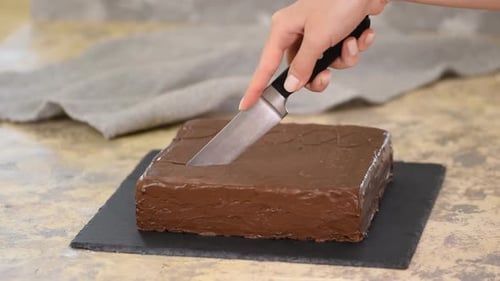 Cutting into a Delicious Chocolate Cake at Home