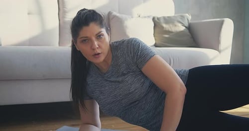 Woman Exercising on Yoga Mat Doing Leg Raises