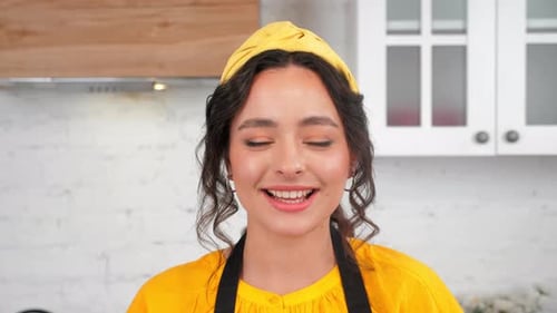 Close Up Smiling Brunette Housewife with Hoop Looking at Camera in Home Kitchen