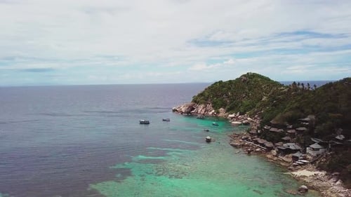 Coral Reef in Turquoise Lagoon Water Beside Rocky Shoreline with Big Stones in Tropical Country