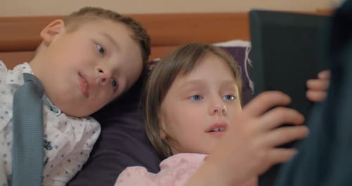 Children Watching Tablet in Bed