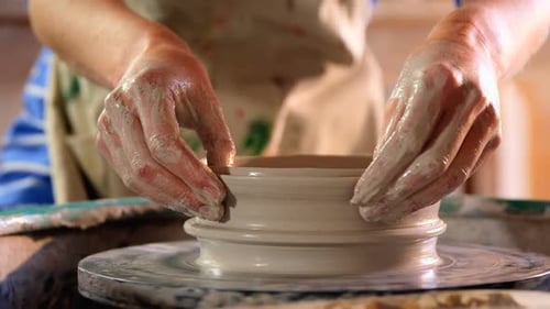 Hands of female potter making a pot