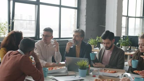 Happy Office Workers Eating Pizza During Work Break Talking Enjoying Food Together
