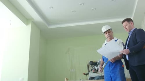 De beaux hommes d'affaires du bâtiment portant des casques de protection se serrent la main