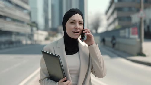 Arabian Woman Talking on Mobile While Walking