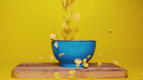 Crispy Corn Flakes Filling a Blue Bowl