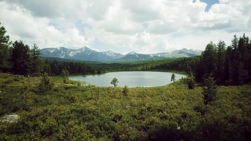 Pequeno lago de montanha com água azul e árvores verdes