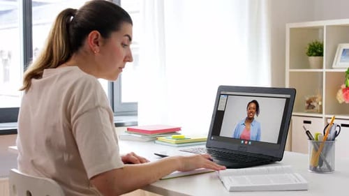 Young Woman Attends Online Class, Takes Notes