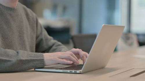 Nahaufnahme der Hände des Menschen, die auf dem Laptop tippen