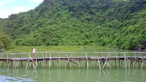 Blond Slim Girl Stands on Old Bridge Makes Selfie in Ha Long Bay