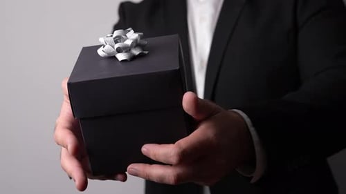 Man Presents Gift Box with Silver Ribbon