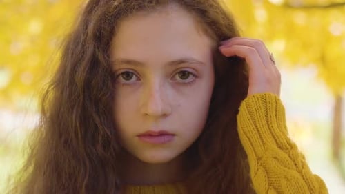 Close-up of a Little Redhead Caucasian Girl Looking at the Camera and Smiling, Child with Long Curly