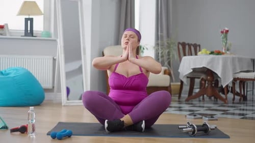 Portrait of Fat Caucasian Young Woman in Lotus Pose Doing Breathing Exercise