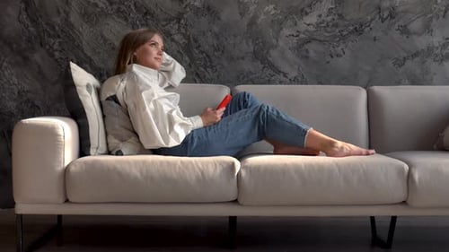 Woman Relaxing on Couch Using Phone