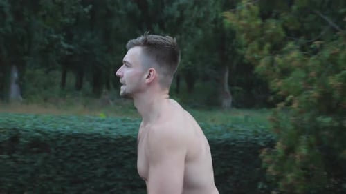 Close Up of Young Muscular Man Sprinting Fast Along Trail Near Forest at Summer Day