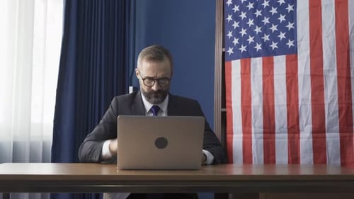 Man at Desk Using Laptop in Office