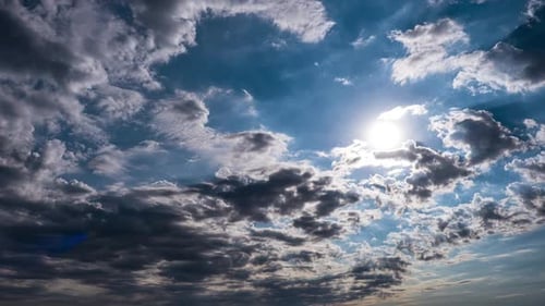 Dramatic Cumulus Cirrus Clouds Move in the Blue Sky. Sunbeams Shine. Time Lapse