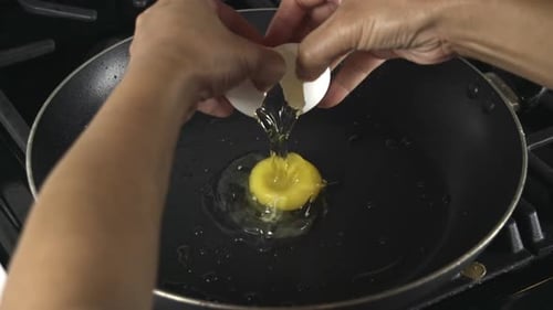 Cracking an Egg into Frying Pan for Cooking