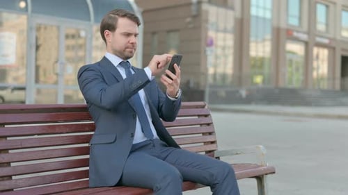 Well Dressed Man Using Cellphone on Bench