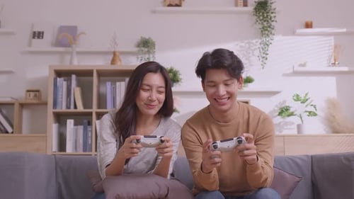 Smiling Couple Playing Video Games at Home