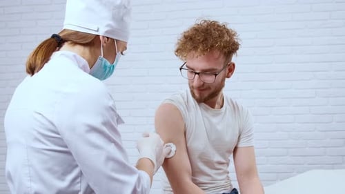 Man Receiving Injection from Healthcare Professional in Hospital