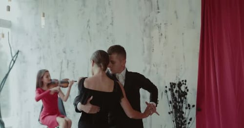 Vista del tango con el acompañamiento del violín por una pareja de bailarines