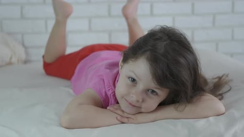 Smiling Girl Lying on Bed at Home