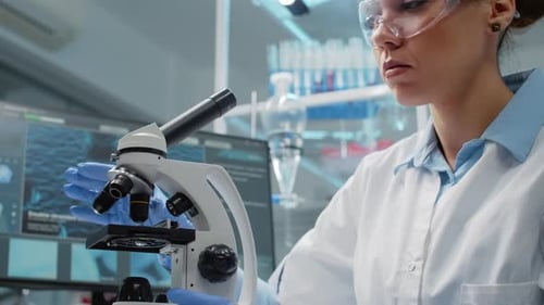 Woman Adjusting Microscope in Modern Laboratory