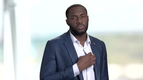 Handsome Man Straightening Collar in Bright Office