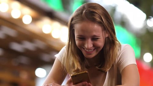 Cute Woman Laughing and Texting Message on Her Phone.