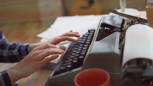 Hands Typing on a Vintage Manual Typewriter