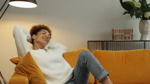 Woman Reclines Comfortably on Cozy Yellow Couch