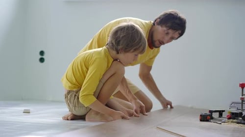 Father and Child Installing Flooring Together Indoors