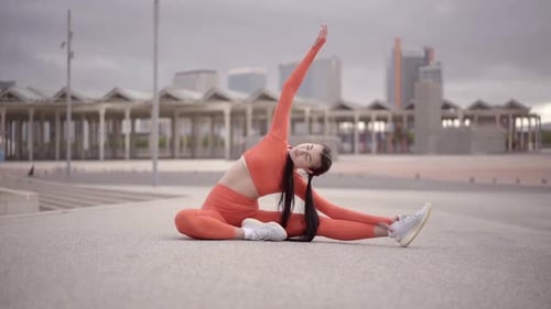 Woman Stretching Body Outdoors on Urban Concrete