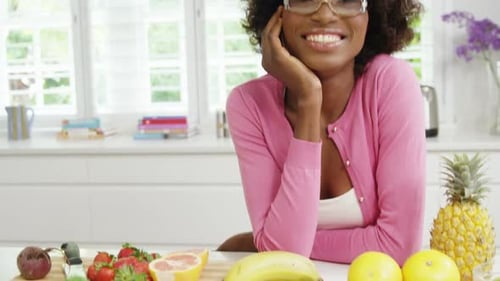 Woman Smiling in Bright Kitchen with Fresh Produce