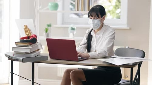 Woman with Mask Working at Home on Laptop
