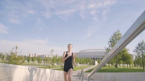 Sports Woman Makes Morning Jog and Physical Exercises In Park